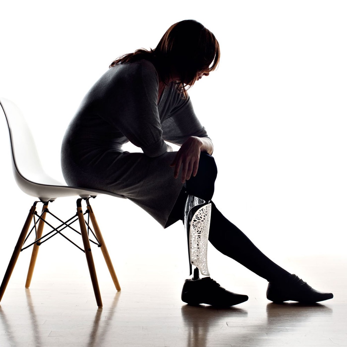 Bespoke Innovations 3D-printed prosthetic leg fairing on a seated model